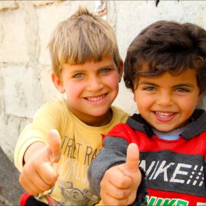 Two young boys giving the thumbs up sign