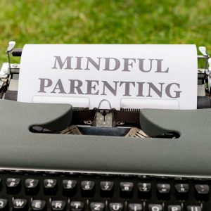 a close up of a typewriter with a paper that says mindful parenting